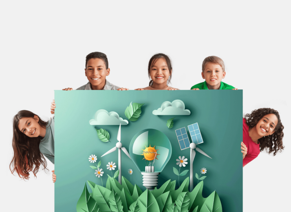 Five children smiling and holding a large poster with eco-friendly illustrations, including a lightbulb with a sun inside, wind turbines, solar panels, and greenery, symbolizing renewable energy and sustainability.